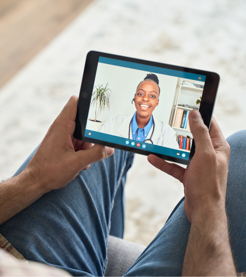 man talking with his primary care physician via tablet man talking with his primary care physician via tablet