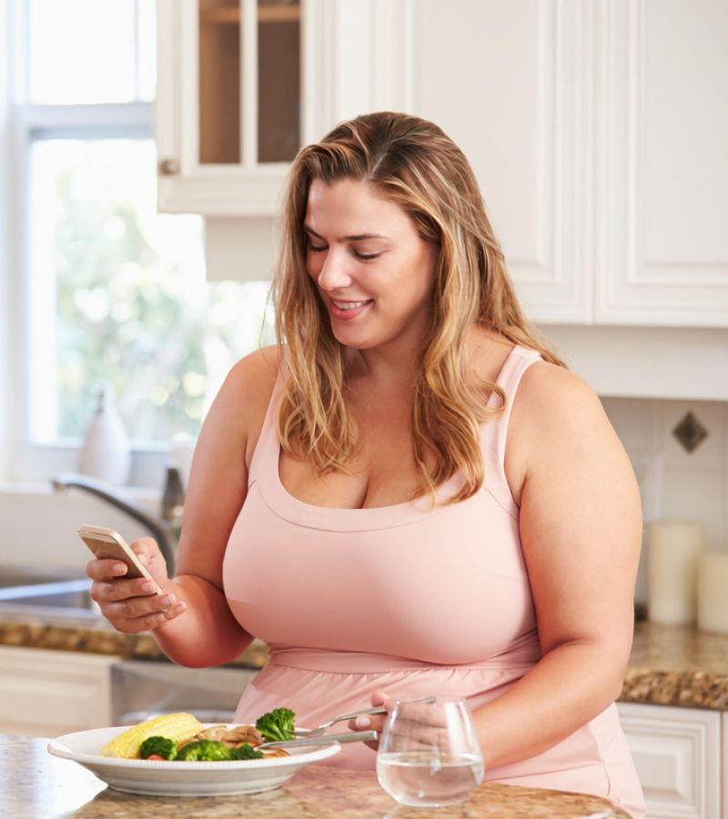 woman checking her phone from her kitchen