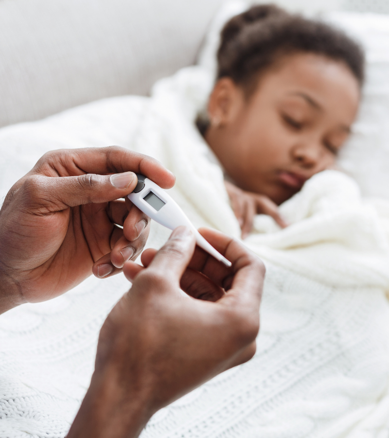 thermometer with a sleeping child in the background