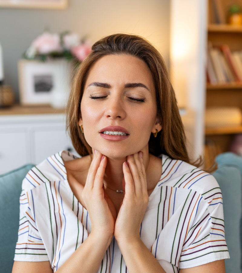 woman feeling her neck