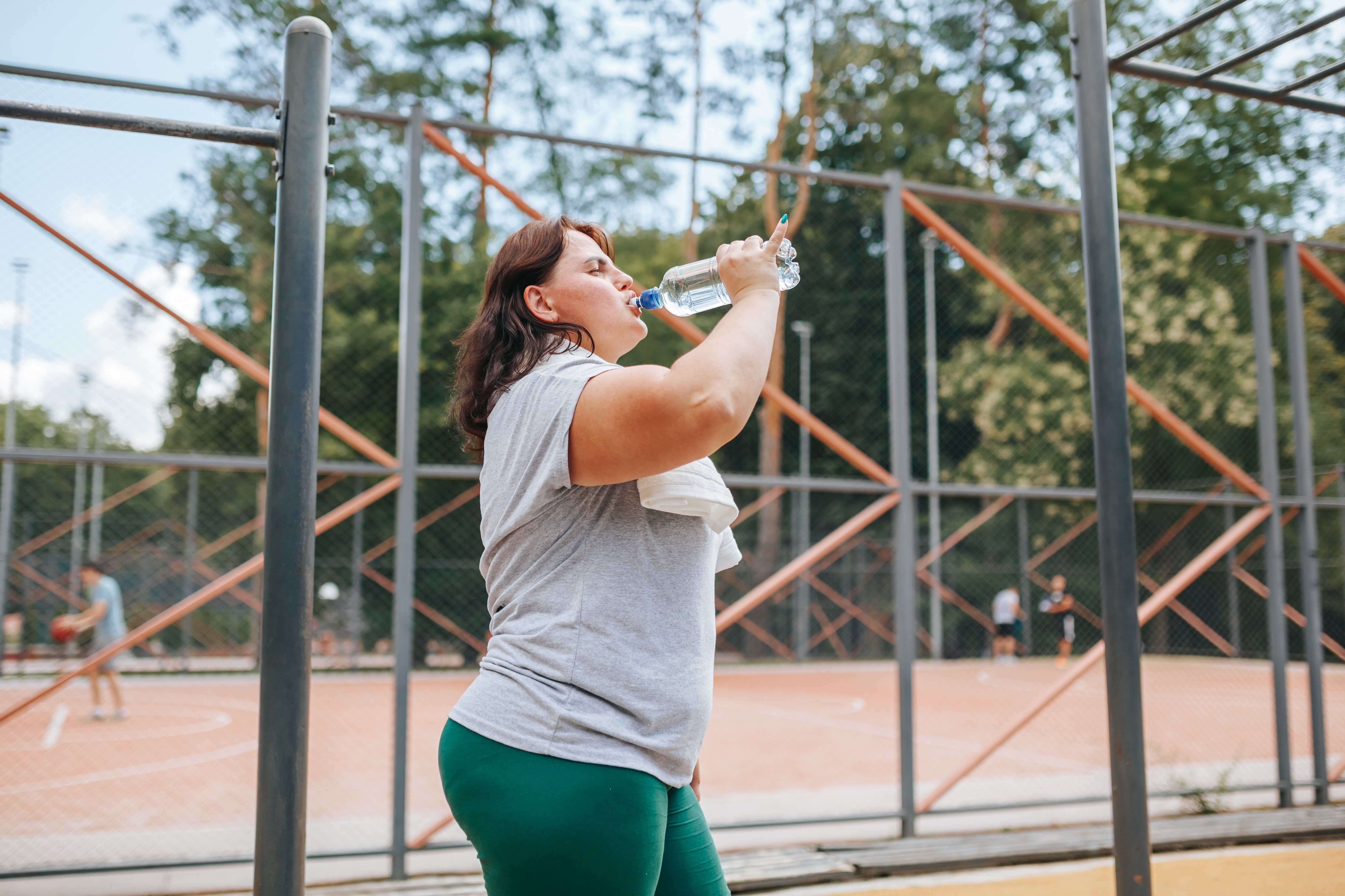 Woman drinking water while walking outside